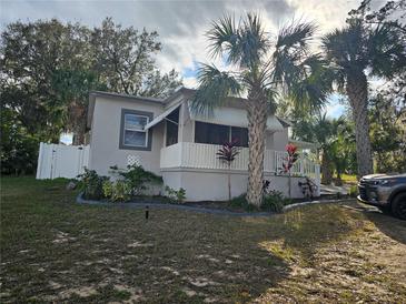 Cute bungalow with white porch and palm trees at 205 Maple W St, Davenport, FL 33837