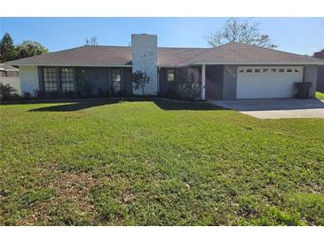 Ranch-style home with a large yard and attached garage at 2314 York Pl, Lakeland, FL 33810