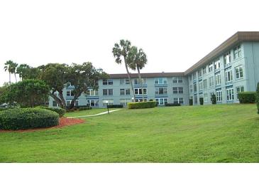 A picturesque exterior view of a multi-story residential building with well-manicured lawn and landscaped greenery at 333 Lake Howard Nw Dr # 202-A, Winter Haven, FL 33880
