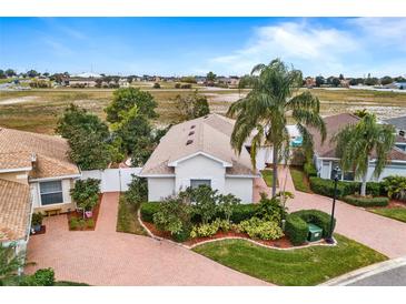 Aerial view of single-story house with landscaped yard and brick driveway at 3457 Raleigh Dr, Winter Haven, FL 33884