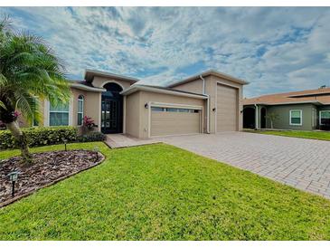 House exterior featuring a two-car garage and manicured lawn at 3834 Litchfield Loop, Lake Wales, FL 33859
