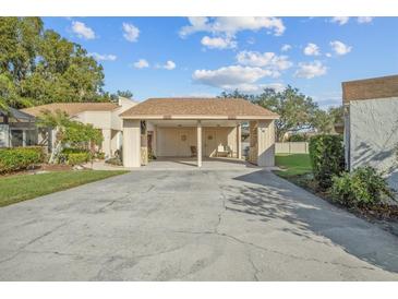 Tan two-story home with carport and landscaped yard at 3966 Oak Loop # 13, Mulberry, FL 33860
