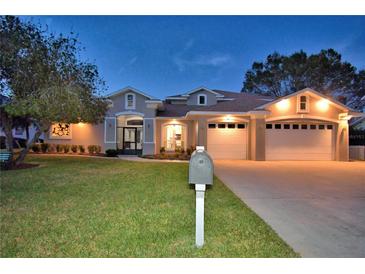 Two-story house with a three-car garage and manicured lawn at dusk at 2119 Kirkland Lake Dr, Auburndale, FL 33823