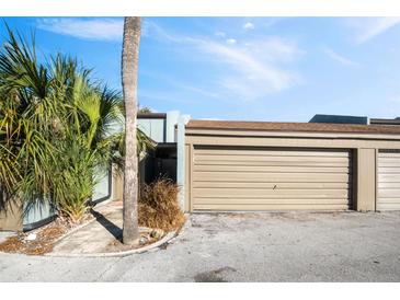 Tan double garage doors with walkway to entrance at 2500 21St Nw St # 22, Winter Haven, FL 33881