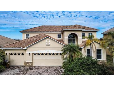 Two-story house with tan exterior, tile roof, and a three-car garage at 3526 Valleyview Dr, Kissimmee, FL 34746
