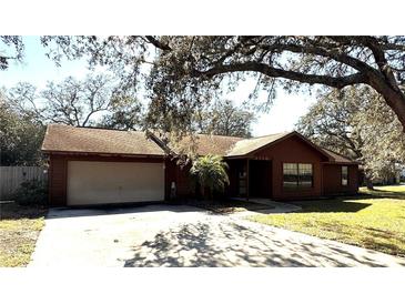 Charming single-story home featuring a two-car garage, mature trees, and well-maintained front lawn at 3710 Black Jack Ct, Lake Wales, FL 33898