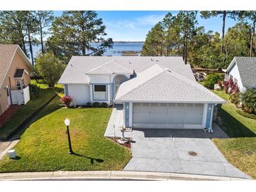 Single-story home with lake view and spacious driveway at 462 Sweetwater Way, Haines City, FL 33844