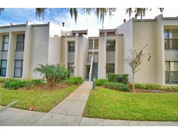 Exterior view of a condo building with landscaping and a walkway at 608 Sweet Bay Cir, Winter Haven, FL 33884