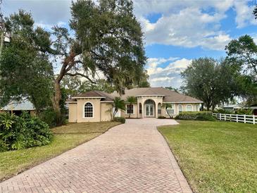 Charming single-story home boasting a beautiful brick driveway and well-manicured lawn with mature trees at 1006 W Lake Hamilton Dr, Winter Haven, FL 33881