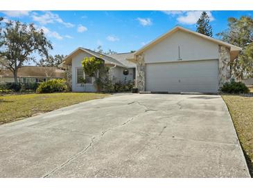 House exterior showcasing a large driveway and well-maintained lawn at 1406 Chamberlain Loop, Lake Wales, FL 33853