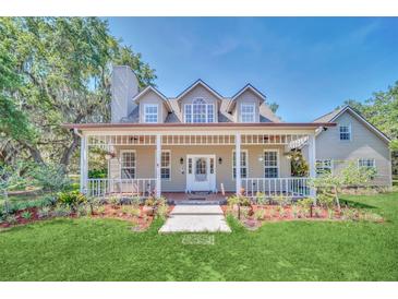 Two-story house with a wraparound porch and landscaped yard at 21113 Kissimmee Shores Rd, Lake Wales, FL 33898