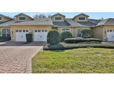 Tan two-story home with two-car garage and landscaped yard at 2739 Rutledge Ct, Winter Haven, FL 33884