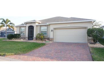 Charming single-story home featuring a brick driveway, manicured lawn, and a neutral-toned exterior with stone accents at 3926 Bedford Ave, Winter Haven, FL 33884