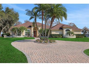Beautiful lakefront home with circular driveway and lush landscaping at 8323 W Lake Marion Rd, Haines City, FL 33844
