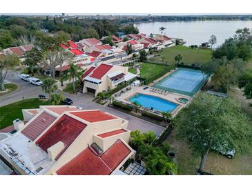 Stunning aerial view of the community showcasing a pool, tennis court, and lake access at 1 Casarena Ct, Winter Haven, FL 33881