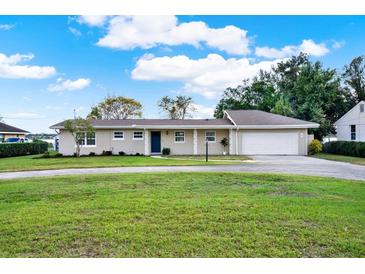 Charming single-story home with well-manicured lawn, circular driveway, and attached garage at 106 Lake Sears Dr, Winter Haven, FL 33880