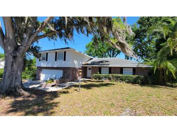 Charming two-story brick home with attached garage and mature trees at 148 Lake Otis Rd, Winter Haven, FL 33884