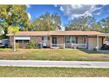 Charming single-story brick home with a well-maintained lawn and a covered porch at 20 24Th Sw St, Winter Haven, FL 33880