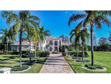 Stunning home featuring lush landscaping, a beautiful brick driveway, and striking architectural details at 3312 Eagles Trce, Winter Haven, FL 33884