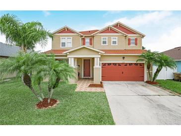 Charming two-story home with a two-car garage and well-manicured lawn with beautiful palm trees at 3526 Warbler Way, Kissimmee, FL 34746