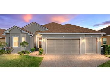 Charming single-story home with a well-manicured lawn, brick driveway, and a two-car garage at 4033 Phoenician Way, Winter Haven, FL 33884