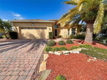 Inviting single-story home featuring a paver driveway, mature palm tree, and well-maintained landscaping at 4540 Turnberry Ln, Lake Wales, FL 33859