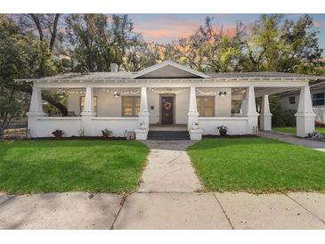 Charming home featuring a spacious front porch decorated with string lights and flowers at 907 Vistabula St, Lakeland, FL 33801