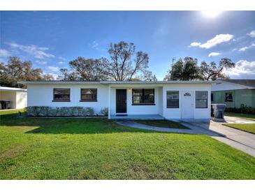 Charming single-story home featuring a well-maintained lawn, tidy landscaping, and a welcoming entryway at 1229 Rawls Dr, Lakeland, FL 33801