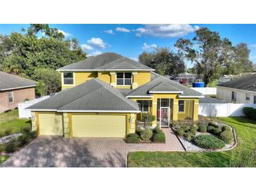 Charming two-story home with a well-manicured lawn and a three car garage and walkway to front door at 1904 Eloise Cove Dr, Winter Haven, FL 33884