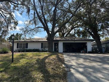 Charming single-story home featuring a well-maintained front yard and mature trees at 229 Durrell Rd, Winter Haven, FL 33884