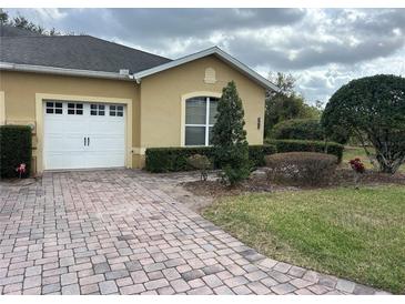 Charming single-Gathering home features an attached garage, brick driveway, and manicured landscaping at 2673 Rutledge Ct, Winter Haven, FL 33884