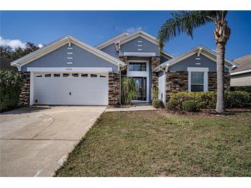 Charming single-story home with a two-car garage, stone accents, and landscaped front yard at 2706 Rochelle Dr, Winter Haven, FL 33881