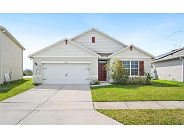 Charming single-story home with a well-maintained lawn and a two-car garage at 2759 Grandbury Grove Rd, Lakeland, FL 33811