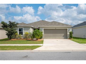 Charming one-story home with a manicured lawn and a two-car garage at 283 Lake Lucerne Way, Winter Haven, FL 33881