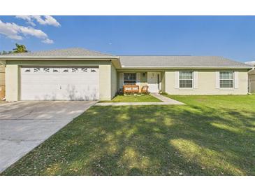 Charming single-story home with a well-manicured lawn and a two-car garage at 31 Wagon Cir, Kissimmee, FL 34743