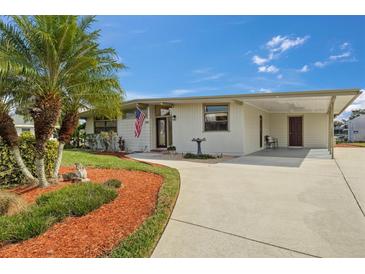 Charming single-story home featuring a well-manicured lawn and covered parking at 326 Canal Dr, Lake Wales, FL 33859