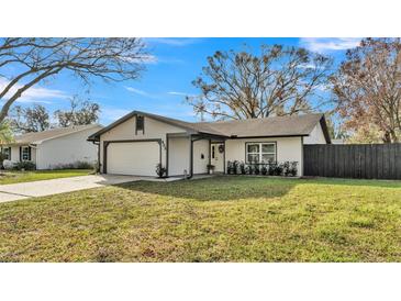 Charming single story home with a well-manicured front yard and attached two car garage at 433 Carleton St, Lakeland, FL 33803