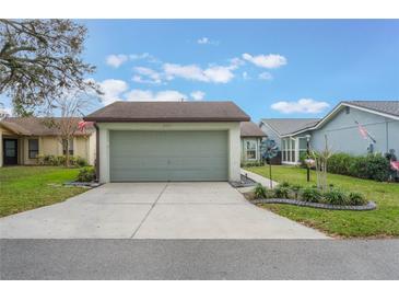 Attached two-car garage with a concrete driveway and well-maintained landscaping at 4422 Glenns Lndg, Winter Haven, FL 33884