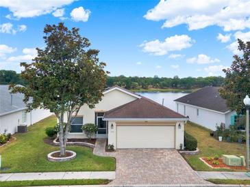 Charming single-story home with a two-car garage and lush landscaping, near a picturesque lake view at 496 Lake Suzanne Dr, Lake Wales, FL 33859