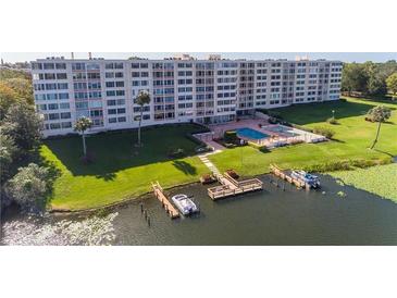 Waterfront condo complex featuring boat docks, a pool, and landscaped grounds at 700 Mirror Nw Ter # 111, Winter Haven, FL 33881