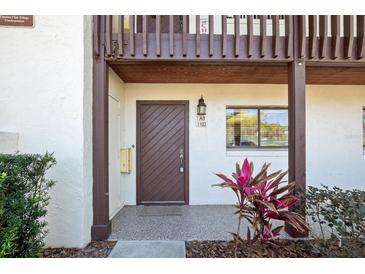 Inviting front door with dark wood finish, house number, and plants adds a welcoming touch at 1103 Country Club Dr # A-3, Lake Wales, FL 33898