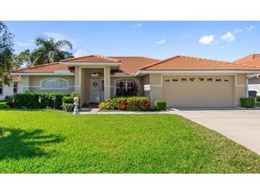 Charming single-story home with a well-manicured lawn, flower beds and an orange tile roof at 123 Morning Glory Cir, Winter Haven, FL 33884