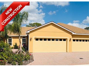 New construction home with a two-car garage, manicured landscaping, and a brick driveway at 1703 Linz Ct, Winter Haven, FL 33884