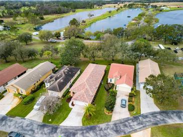 A vibrant aerial view showcasing homes nestled amidst lush landscaping and serene lakes at 20143 Sunset Landing Ave, Groveland, FL 34736