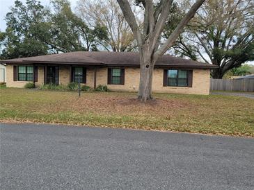 Charming one-story brick home featuring a well-maintained yard and mature trees at 2016 Amesbury Dr, Auburndale, FL 33823