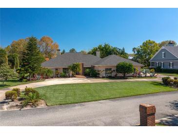 Charming single-story home boasts a circular driveway, mature landscaping, and neutral color palette at 2506 Partridge Dr, Winter Haven, FL 33884