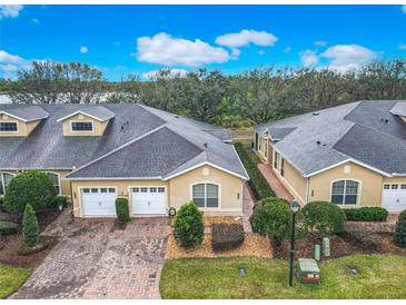 An aerial view of townhomes featuring brick driveways, attached garages, and manicured landscaping at 2723 Rutledge Ct, Winter Haven, FL 33884