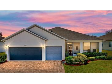Charming single-story home featuring a brick driveway, two-car garage, and meticulously landscaped front yard at 3686 Plymouth Dr, Winter Haven, FL 33884