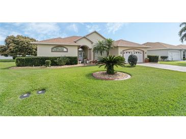 Charming single-story home with a well-manicured lawn, mature landscaping, and a two-car garage at 415 Ruby Lake Pl, Winter Haven, FL 33884