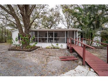 Inviting home featuring a screened porch, complemented by mature trees and unique ramp access at 428 Garrett Ridge Ct, Winter Haven, FL 33880